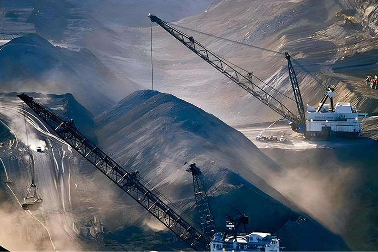 Large mining site with electric mining trucks and cranes operating among piles of minerals, representing battery-swap technology for heavy-duty EVs.