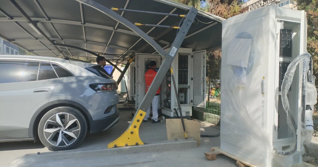 Commercial EV charging station installation with technicians and electric vehicles.