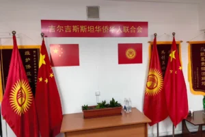 Indoor meeting room with Chinese and Kyrgyz flags, symbolizing cooperation on EV charging stations and clean energy projects.