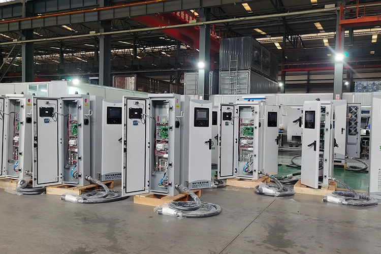 Factory workshop assembling custom Level 3 DC fast chargers with open cabinets showing internal components.